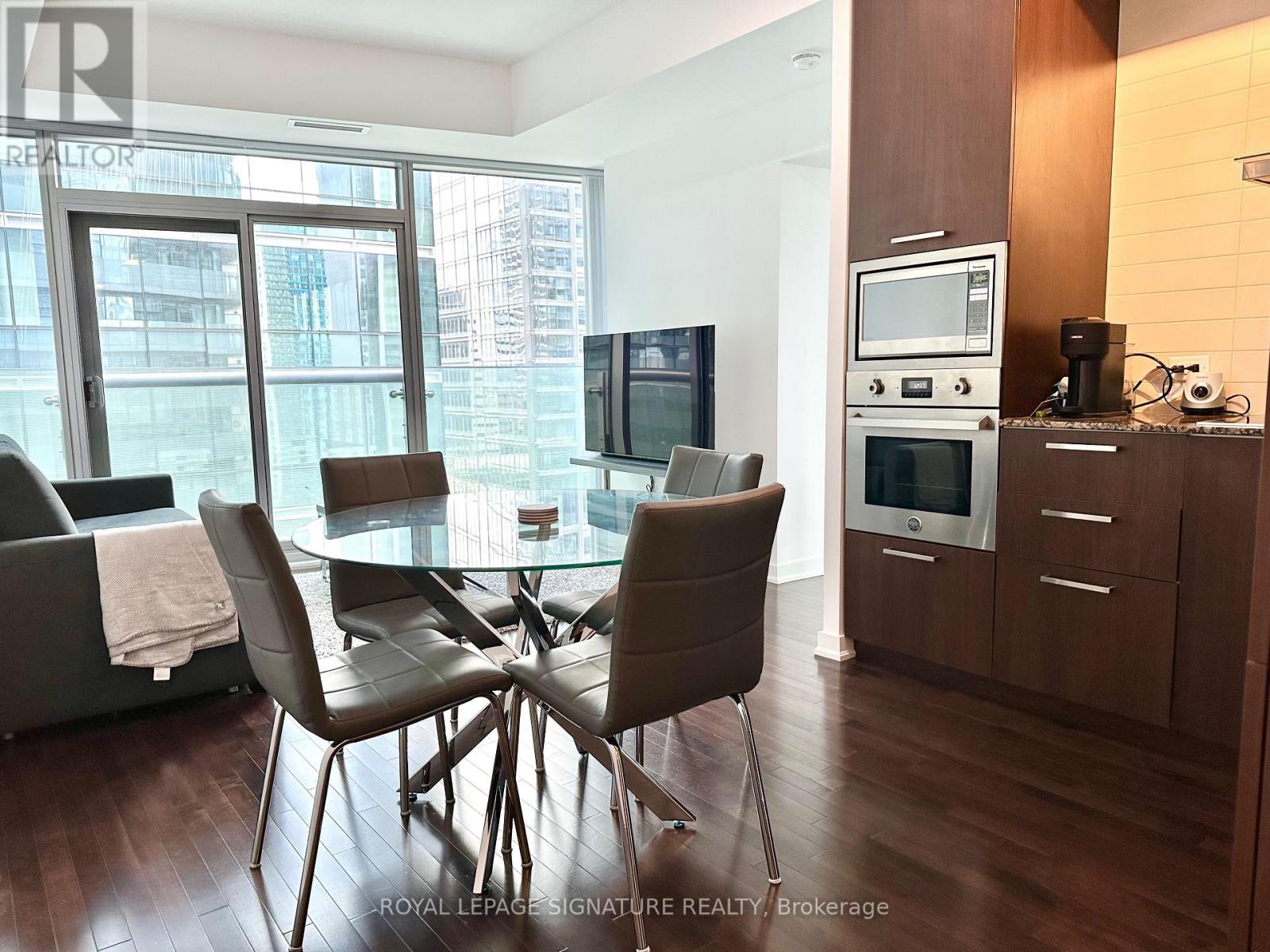 A modern dining room with a glass table and chairs.
