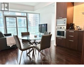 A modern dining room with a glass table and chairs.