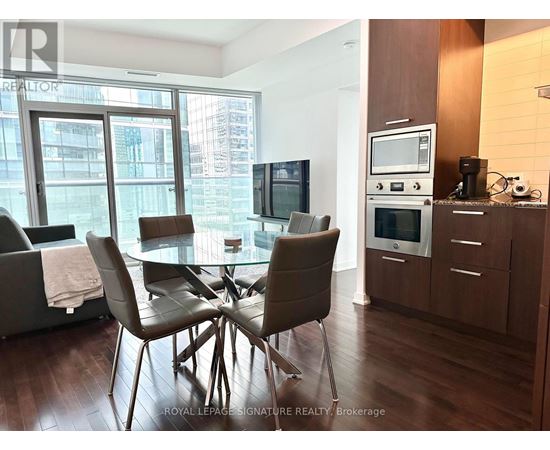 A modern dining room with a glass table and chairs.