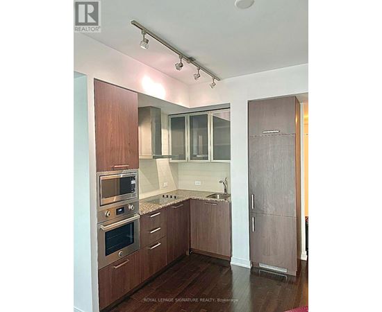 A kitchen with wooden cabinets and stainless steel appliances.