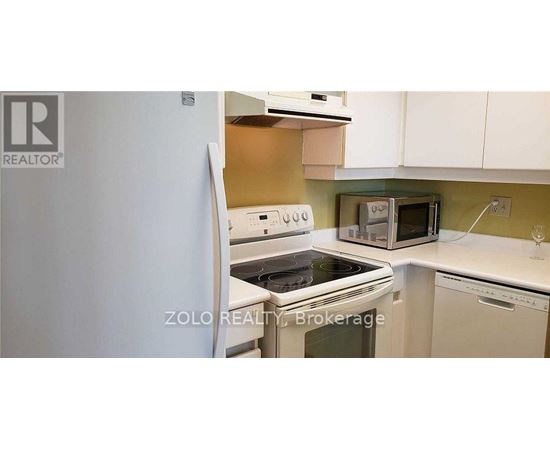 A kitchen with a white refrigerator and a white stove top oven.