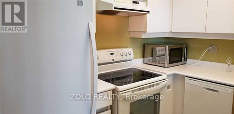 A kitchen with a white refrigerator and a white stove top oven.
