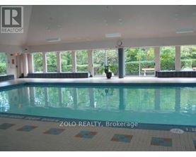 A pool inside a building with the logo of Zolo Realty, Brokerage on the bottom.