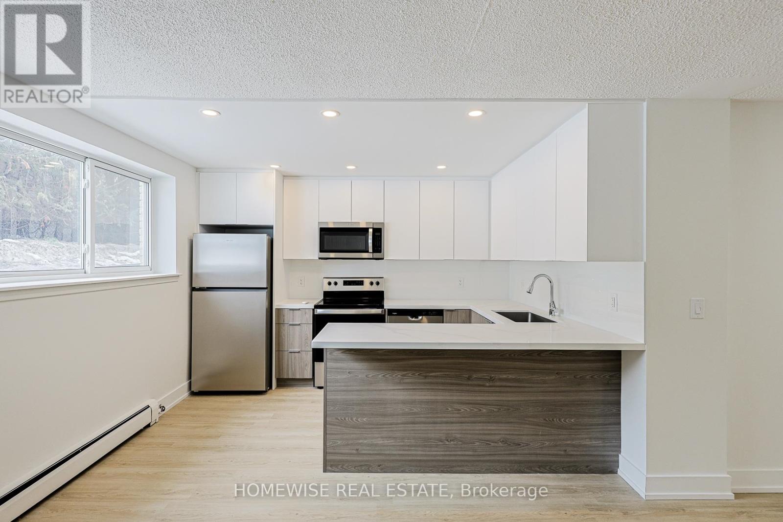 A kitchen with white cabinets and a wooden island.