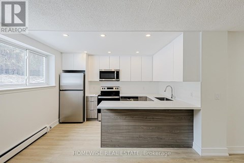 A kitchen with white cabinets and a wooden island.