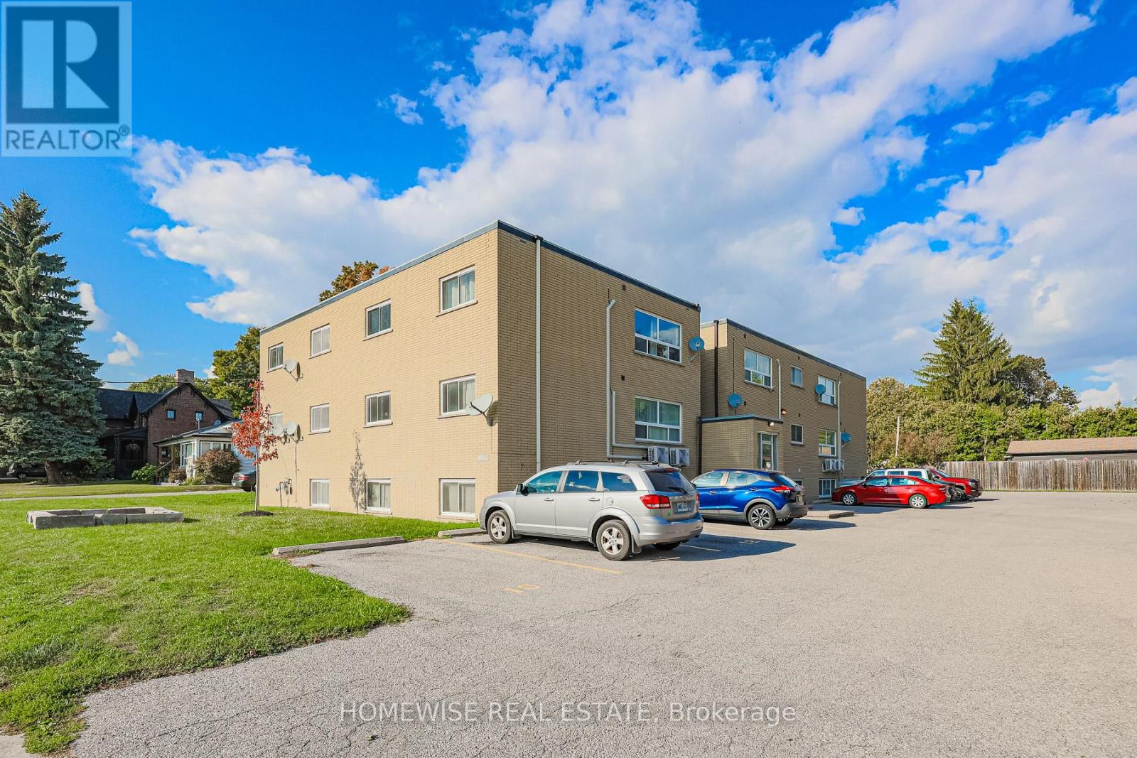 A building with a car parked in front of it and a sign that says "HOMEWISSE REAL ESTATE Brokerage".