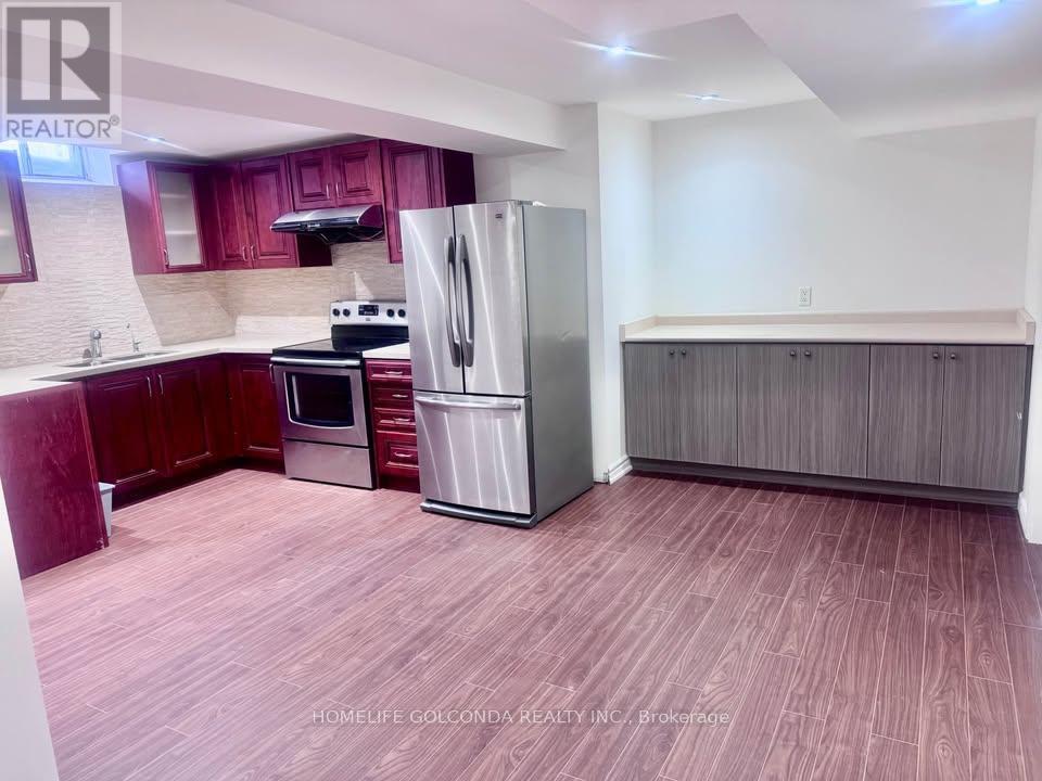 A kitchen with a refrigerator, oven, and microwave.