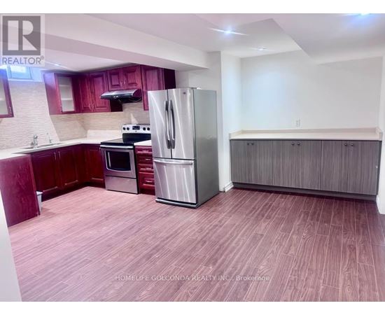 A kitchen with a refrigerator, oven, and microwave.