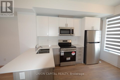 A kitchen with white cabinets and stainless steel appliances.