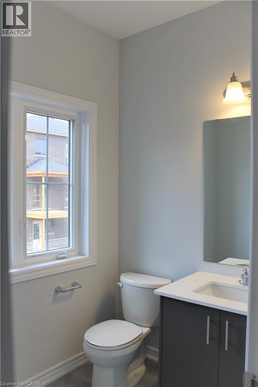 A bathroom with a toilet, sink and window.