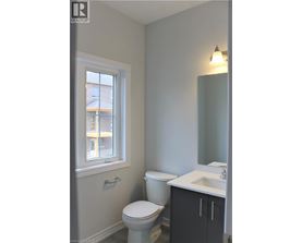 A bathroom with a toilet, sink and window.