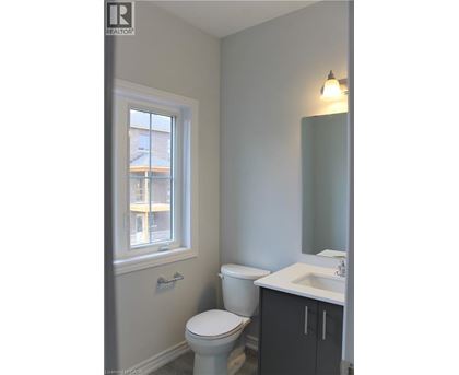 A bathroom with a toilet, sink and window.