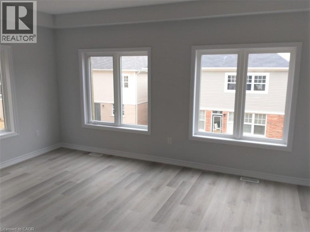 A room with a grey wall and a window with a view of a building.