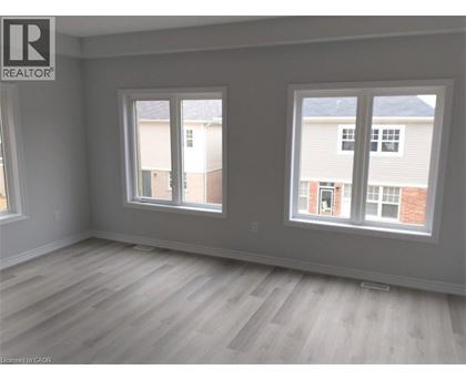 A room with a grey wall and a window with a view of a building.