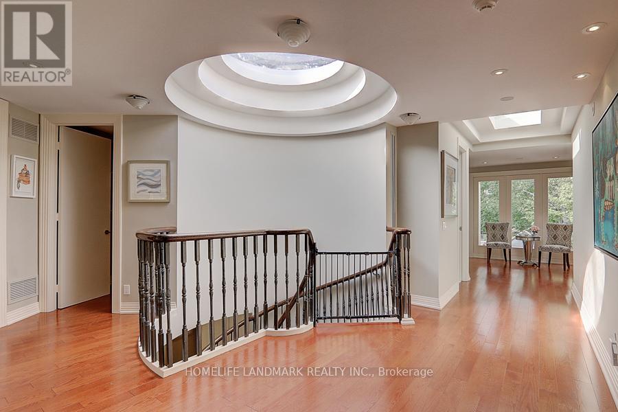 A spacious foyer with a curved staircase and a skylight.