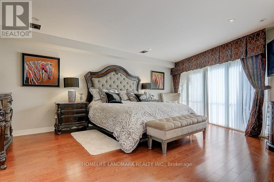A bedroom with a large bed and a wooden floor.