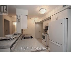 A kitchen with a sink, refrigerator, and microwave.
