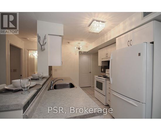 A kitchen with a sink, refrigerator, and microwave.