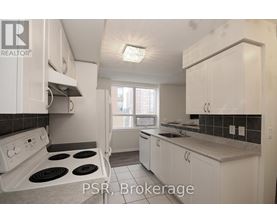 A kitchen with white cabinets and a stove top oven.