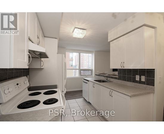 A kitchen with white cabinets and a stove top oven.