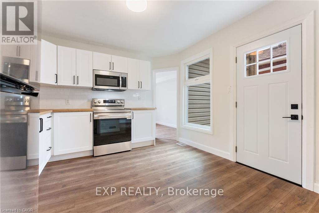 A kitchen with white cabinets and a wooden floor.
