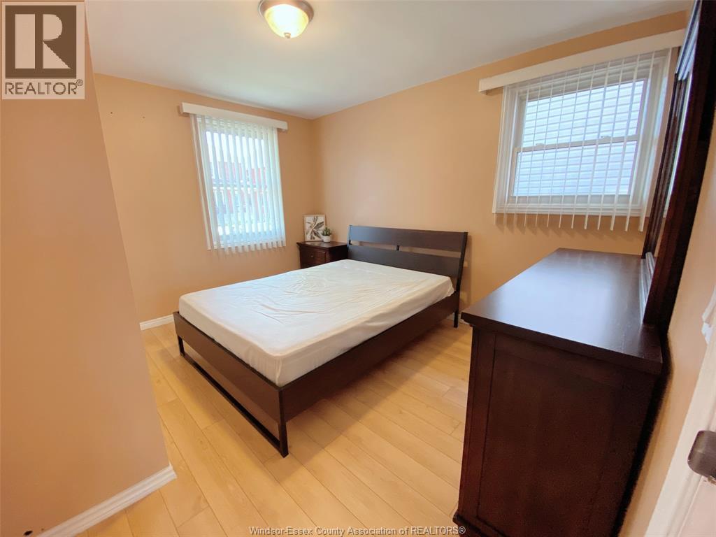 A bedroom with a bed, nightstand, and window.