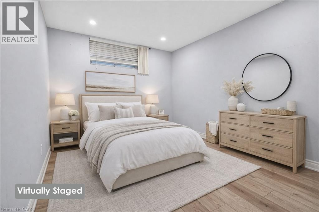 A bedroom with a large bed, a dresser, and a nightstand with lamps.