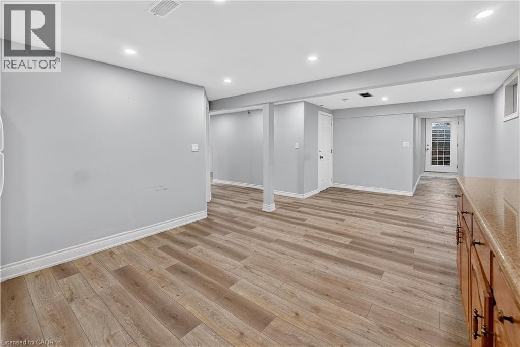 A spacious room with wooden flooring and white walls.
