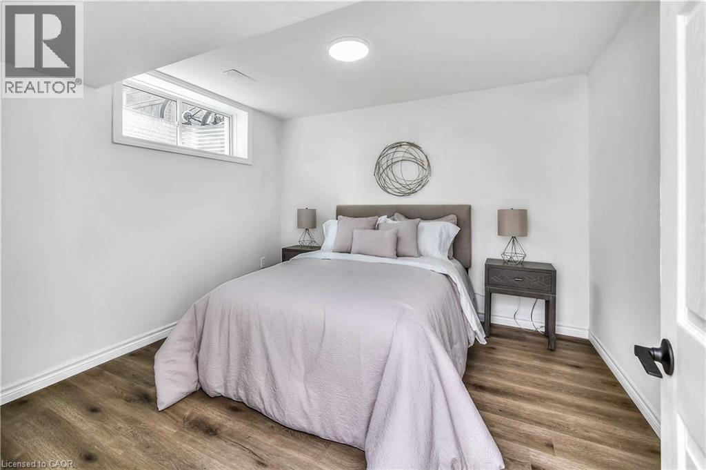 A bedroom with a bed, nightstand, and a window.