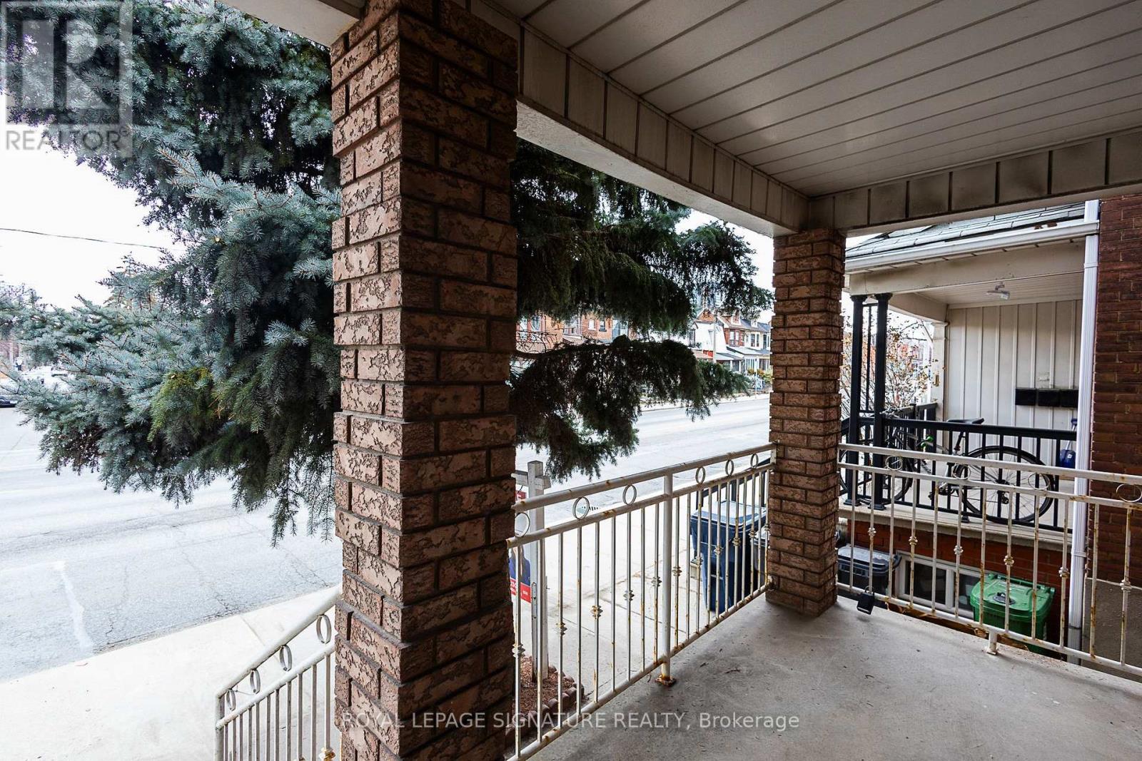 A balcony with a brick pillar and a metal railing.
