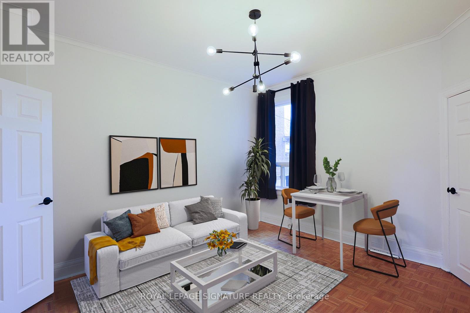 A living room with a white couch, a coffee table, and a painting on the wall.