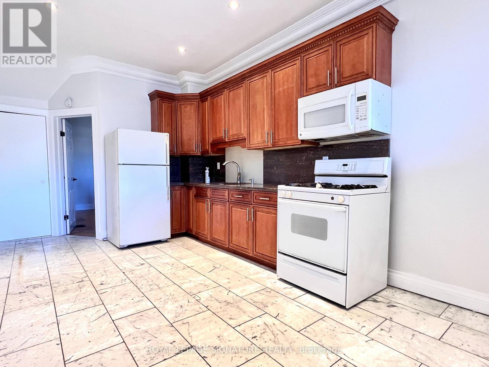 A kitchen with wooden cabinets and a white fridge.