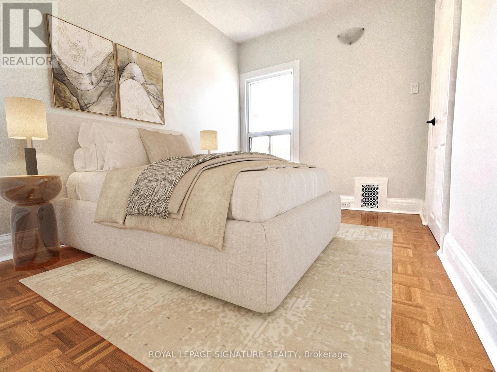 A bedroom with a large bed and a wooden floor.