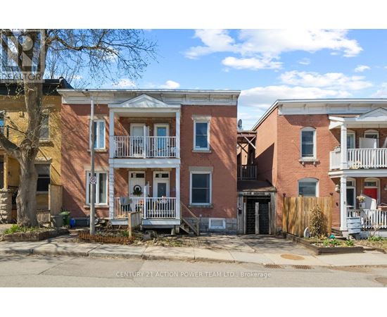 A row of townhouses with a sign that says Century 21 Action Power Team Ltd, Brokerage.