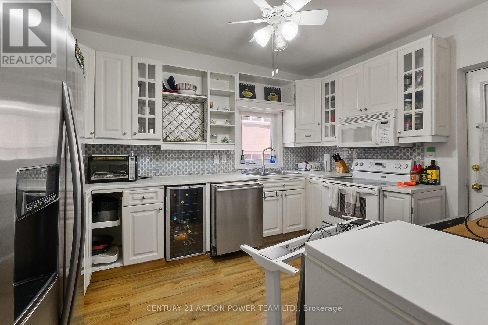 A kitchen with white cabinets and a refrigerator.
