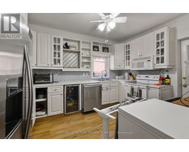 A kitchen with white cabinets and a refrigerator.