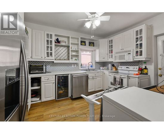 A kitchen with white cabinets and a refrigerator.