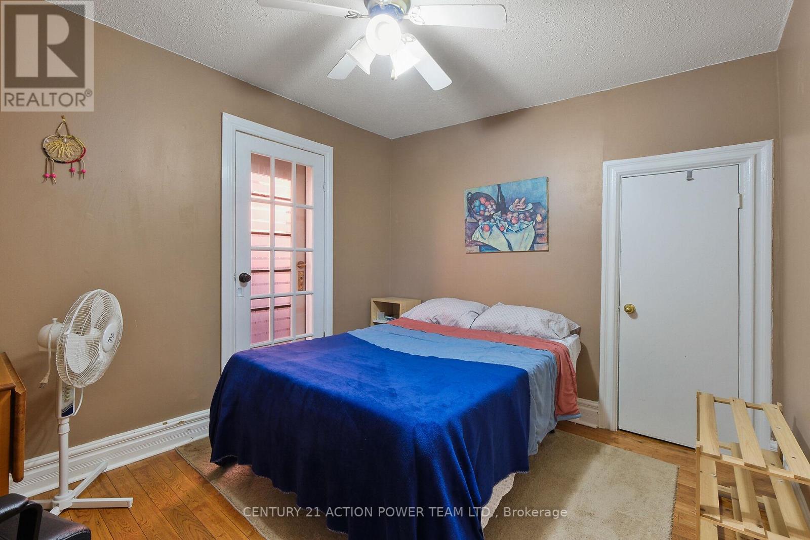 A bedroom with a bed covered in a blue bedspread.