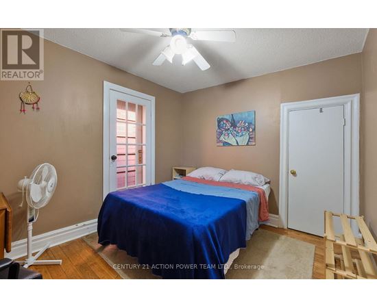 A bedroom with a bed covered in a blue bedspread.