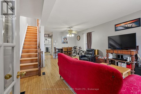 A living room with a red couch and a staircase.