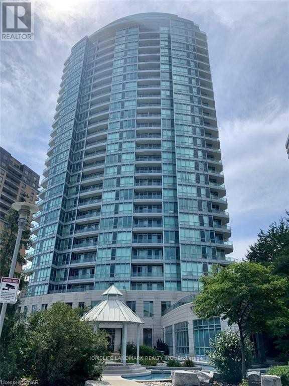 A tall building with a pool in front of it.