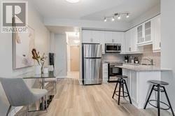 A modern kitchen with a dining table and bar stools.