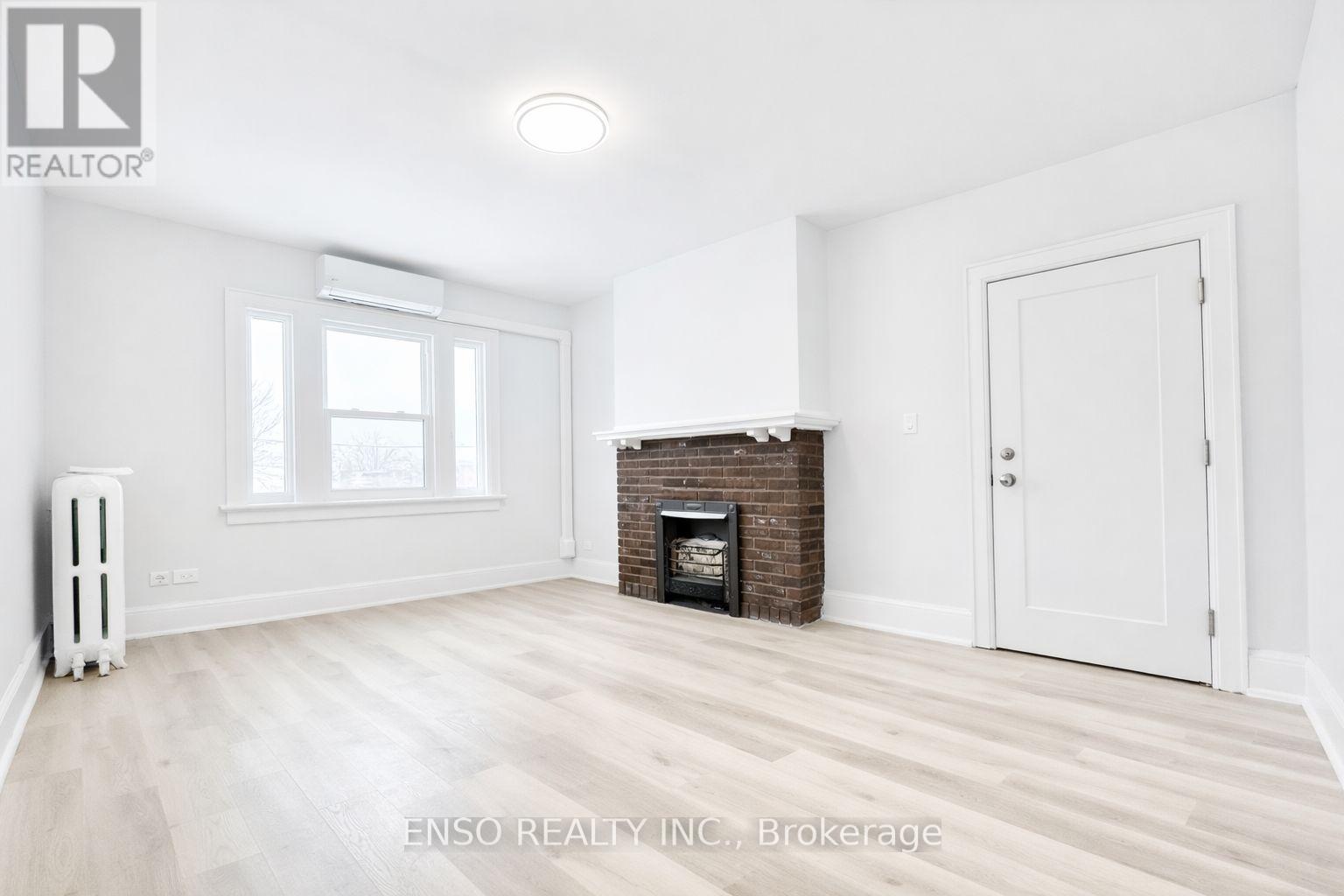 A white room with a fireplace and a window.