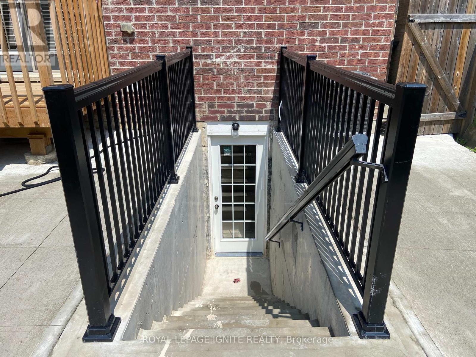 A black railing on a concrete staircase with a door in the middle.