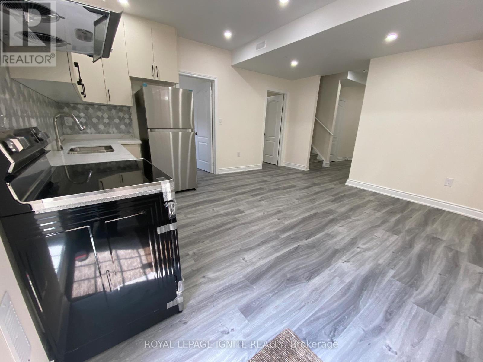 A kitchen with a black oven and a grey floor.