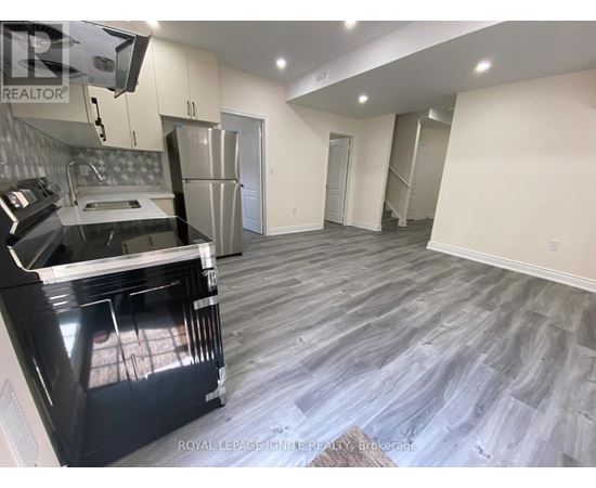 A kitchen with a black oven and a grey floor.
