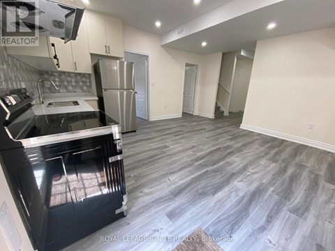 A kitchen with a black oven and a grey floor.