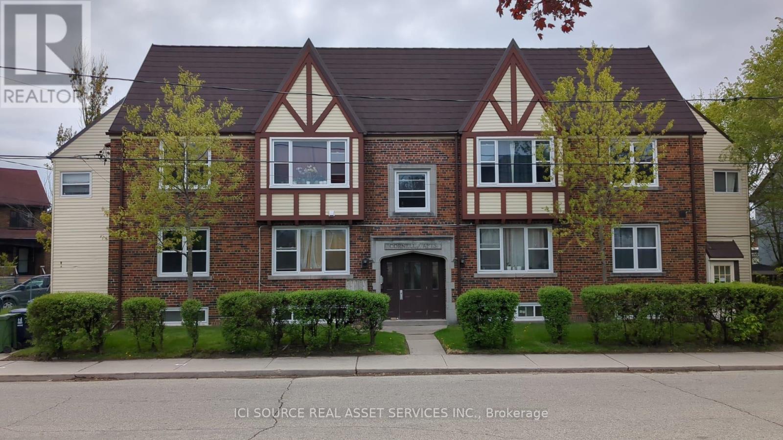 A brick house with a brown roof and a white garage door.