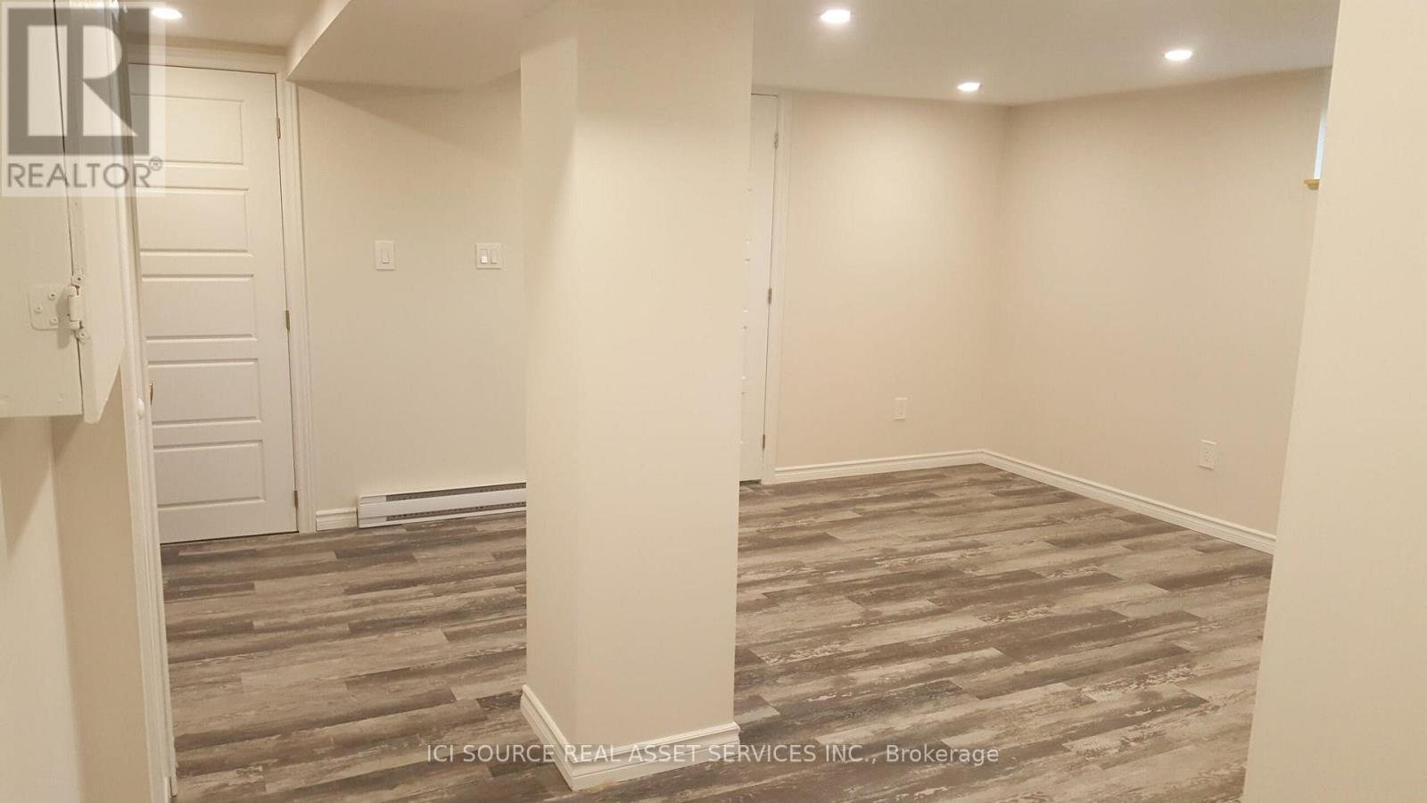 A room with a wooden floor and white walls.