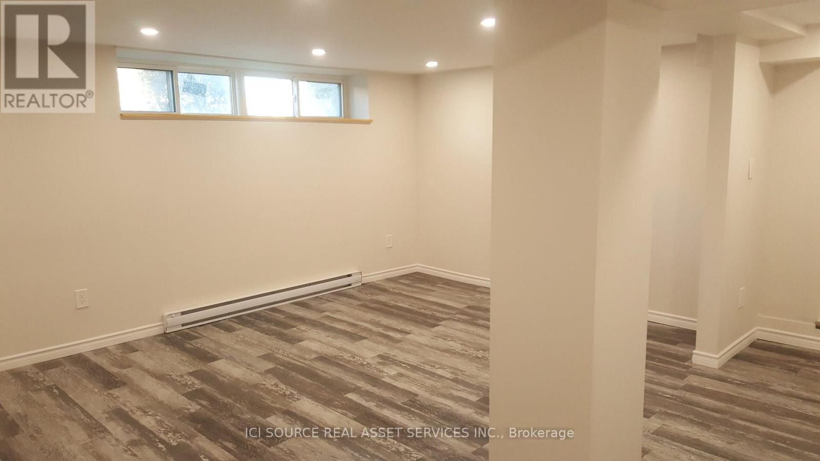 A room with a carpeted floor and a window.